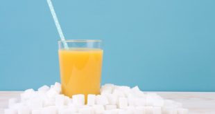 Glass of orange juice with plenty of sugar cubes