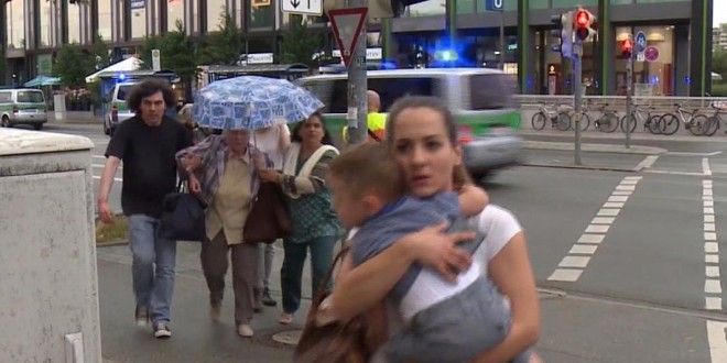 Members of the public run away from the Olympia Einkaufszentrum mall  after a shooting  in Munich  Germany  Friday  July 22  2016  A manhunt was underway Friday for a shooter or shooters who opened fire at a shopping mall in Munich  killing and wounding several people  a Munich police spokeswoman said  The city transit system shut down and police asked people to avoid public places   AP