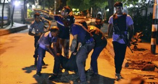 People help an unidentified injured person after a group of gunmen attacked a restaurant popular with foreigners in a diplomatic zone of the Bangladeshi capital Dhaka  Bangladesh  Friday  July 1  2016  A group of gunmen attacked a restaurant popular with foreigners in a diplomatic zone of the Bangladeshi capital on Friday night  taking hostages and exchanging gunfire with security forces  according to a restaurant staff member and local media reports   AP Photo