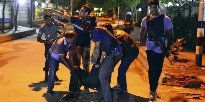 People help an unidentified injured person after a group of gunmen attacked a restaurant popular with foreigners in a diplomatic zone of the Bangladeshi capital Dhaka  Bangladesh  Friday  July 1  2016  A group of gunmen attacked a restaurant popular with foreigners in a diplomatic zone of the Bangladeshi capital on Friday night  taking hostages and exchanging gunfire with security forces  according to a restaurant staff member and local media reports   AP Photo