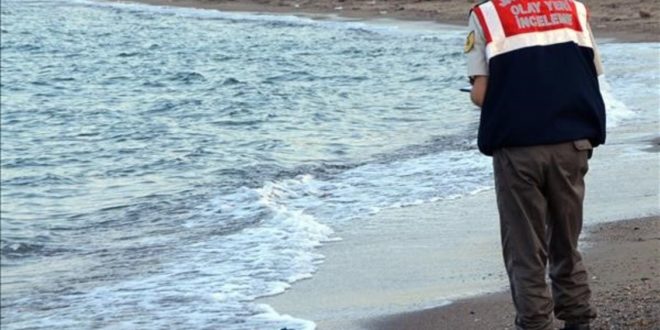 FILE - In this Wednesday  Sept  2  2015 file photo  a paramilitary police officer investigates the scene before carrying the body of 3-year-old Aylan Kurdi from the sea shore  near the beach resort of Bodrum  Turkey  A number of migrants are known to have died and some are still reported missing  after boats carrying them to the Greek island of Kos capsized   AP Photo DHA  File  TURKEY OUT