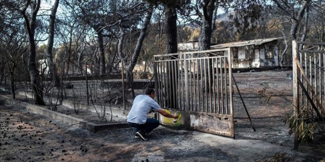 A expert marks with paint a burnt house following a wildfire at the village of Neos Voutzas  near Athens on July 26  2018  Greece was counting the cost on July 26 of its deadliest wildfires in living memory  as emergency crews searched incinerated homes and vehicles for the missing after at least 81 people were confirmed to have died    AFP PHOTO   ANGELOS TZORTZINIS