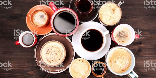 Many cups of coffee on wooden table